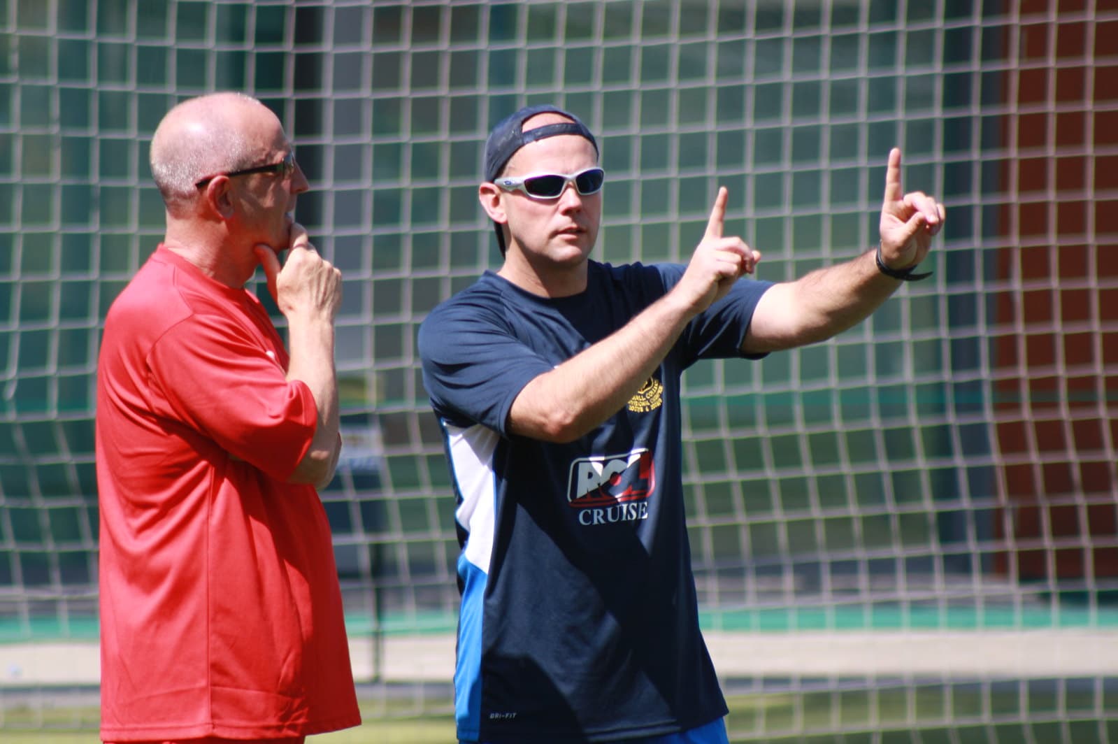 Two youth soccer coaches discussing tactical approaches during training